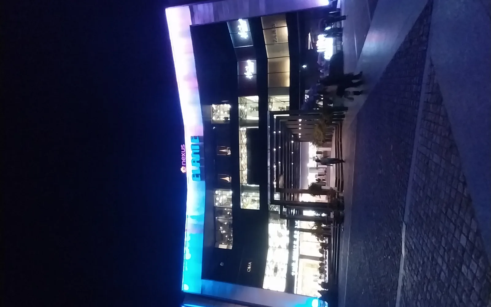 Shopping mall illuminated at night with modern architecture